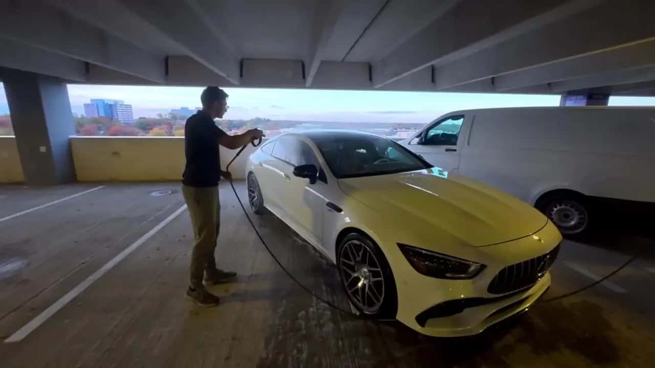 Fairfax Shine technician pressure washing a white Mercedes-AMG during car detailing in Fairfax, VA